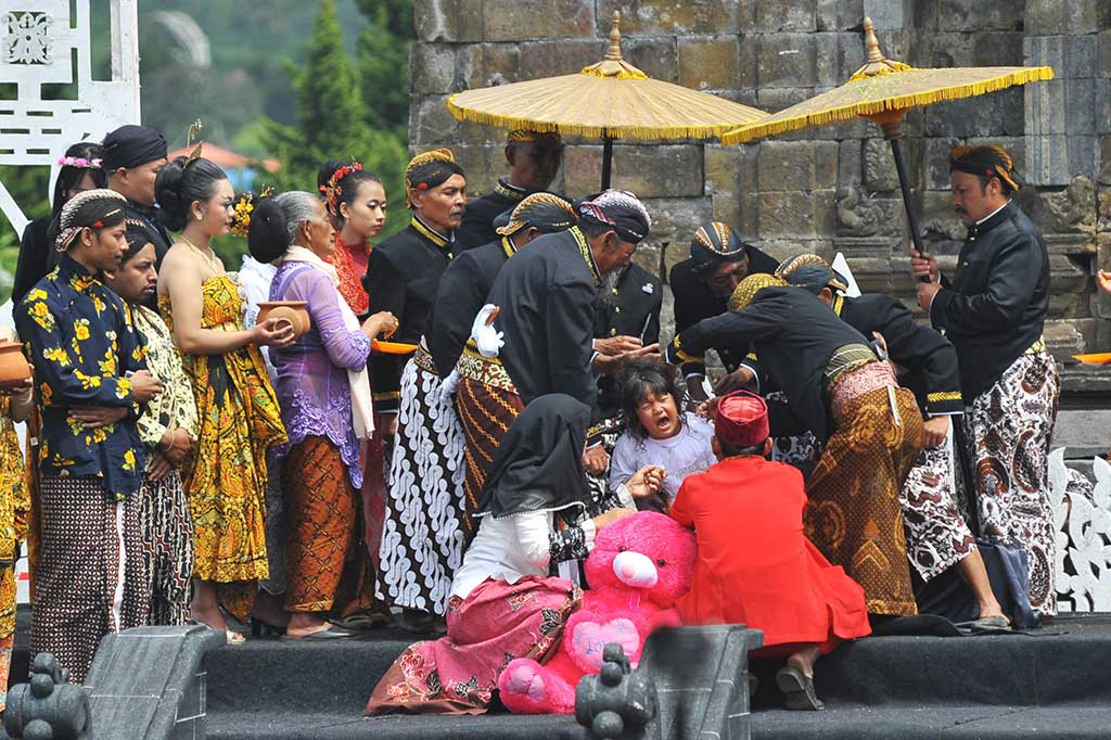 Sesepuh adat memotong rambut seorang anak bajang saat berlangsung tradisi Potong Rambut Gimbal.