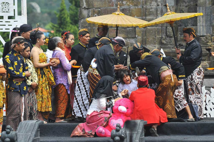 Sesepuh adat memotong rambut seorang anak bajang saat berlangsung tradisi Potong Rambut Gimbal.