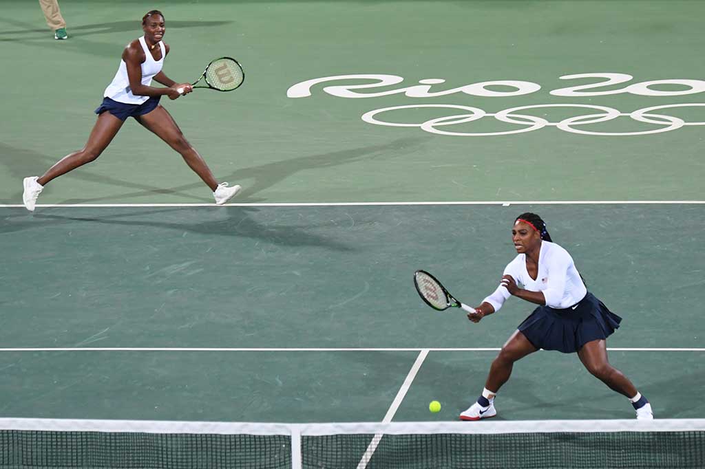 Venus Williams berusaha mengembalikan bola ke arah pasangan Barbora Strycova dan Lucie Safarova.