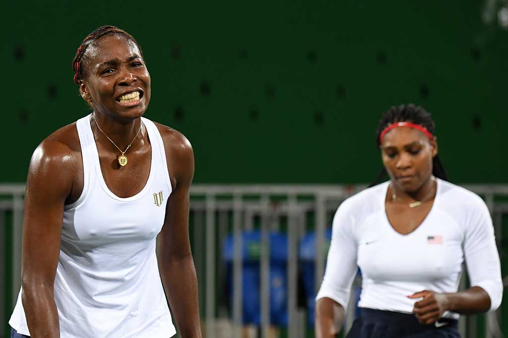 Serena (kanan) dan Venus Williams kecewa setelah dikalahkan pasangan Ceko.