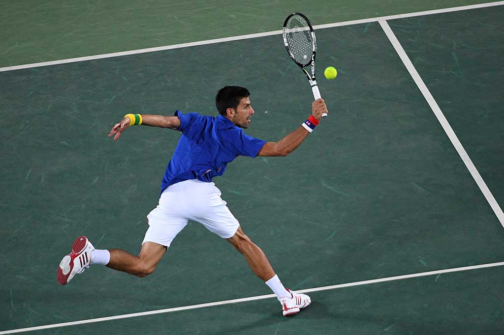 Novak Djokovic berusaha mengembalikan bola ke arah Juan Martin del Potro.