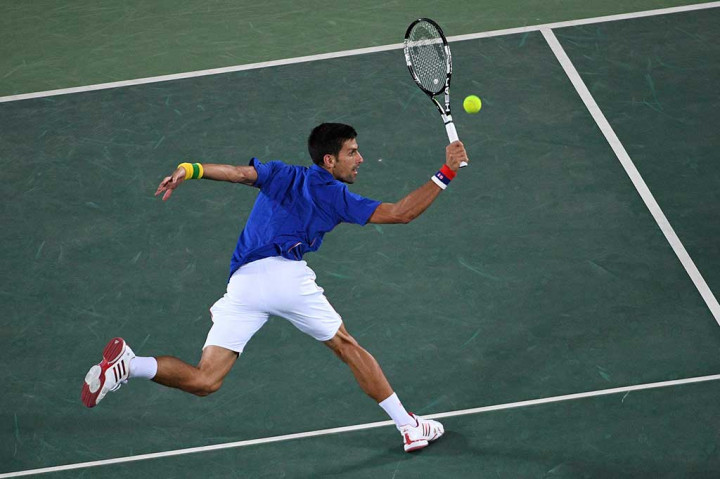 Novak Djokovic berusaha mengembalikan bola ke arah Juan Martin del Potro.
