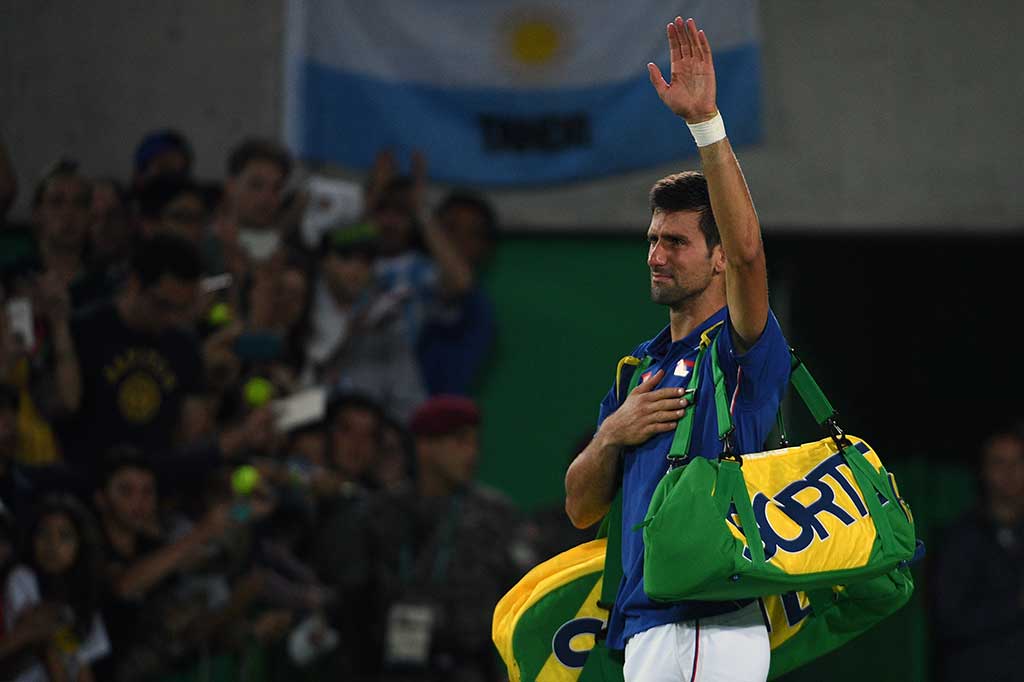 Djokovic melambaikan tangan kepada para fan saat akan keluar dari arena pertandingan.