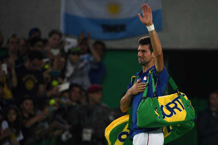 Djokovic melambaikan tangan kepada para fan saat akan keluar dari arena pertandingan.