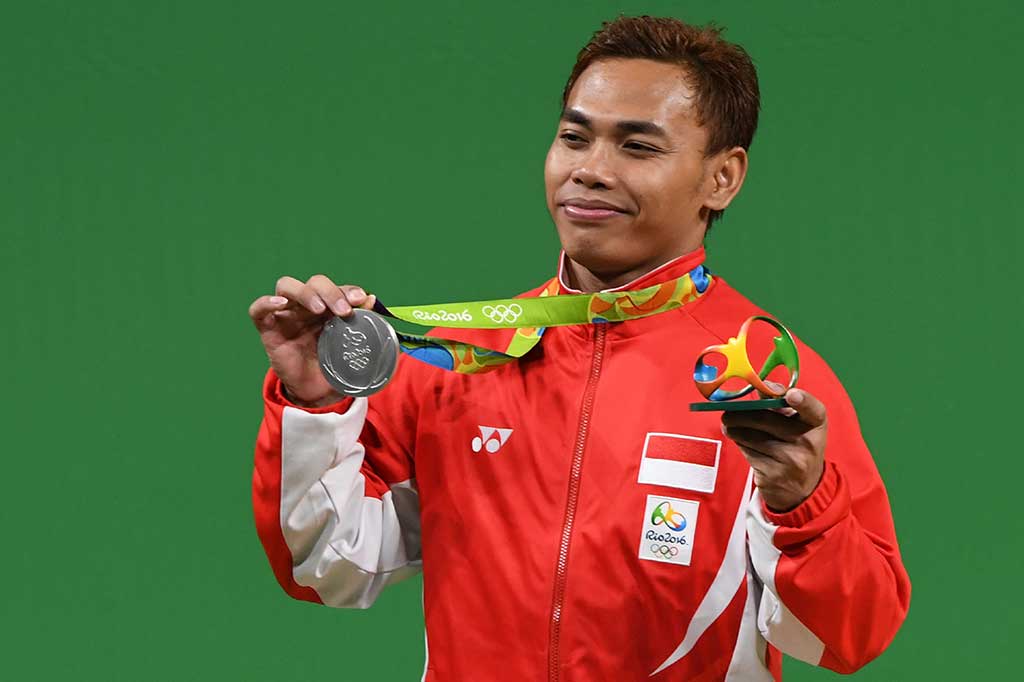 Eko Yuli mengangkat medali perunggu yang dia raih.