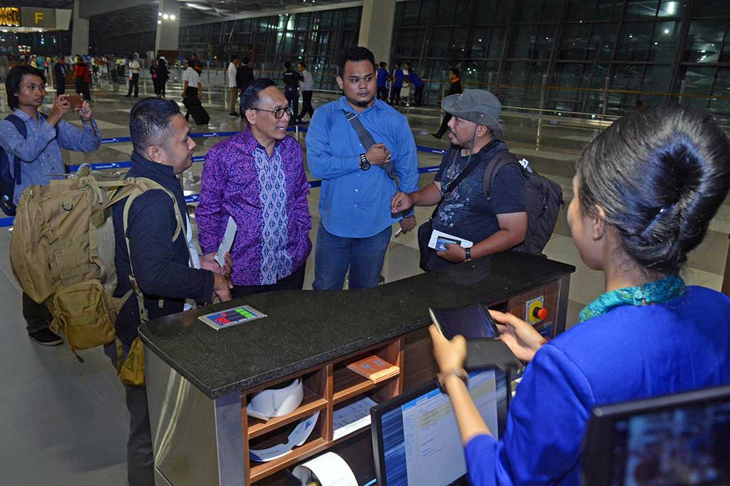 Direktur Utama Garuda Indonesia M Arif Wibowo (kedua kiri) berbincang dengan penumpang di boarding gate Terminal 3 Bandara Soekarno Hatta.