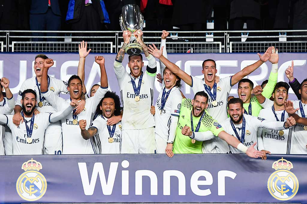 Para pemain Real Madrid melakukan selebrasi bersama trofi Piala Super Eropa yang baru saja mereka raih.