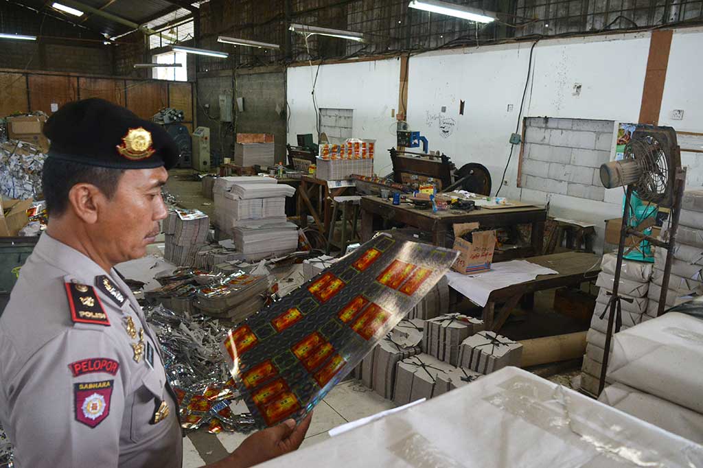 Seorang Polisi memeriksa bahan baku produksi jamu ilegal di Pasar Kemis.
