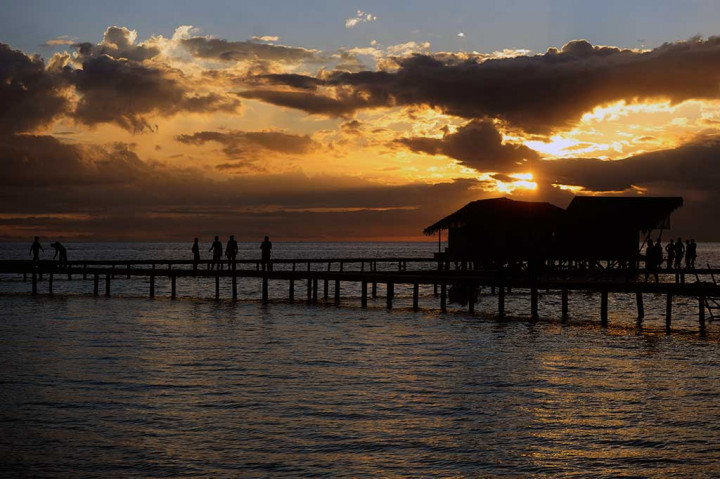 Wisatawan berjalan di jembatan sekitar hotel yang dibangun di Pulau Cinta.