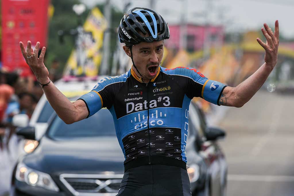 Saxon Irvine melakukan selebrasi saat menyentuh finis pertama pada etape ketujuh Tour de Singkarak 2016.