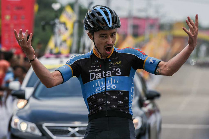 Saxon Irvine melakukan selebrasi saat menyentuh finis pertama pada etape ketujuh Tour de Singkarak 2016.