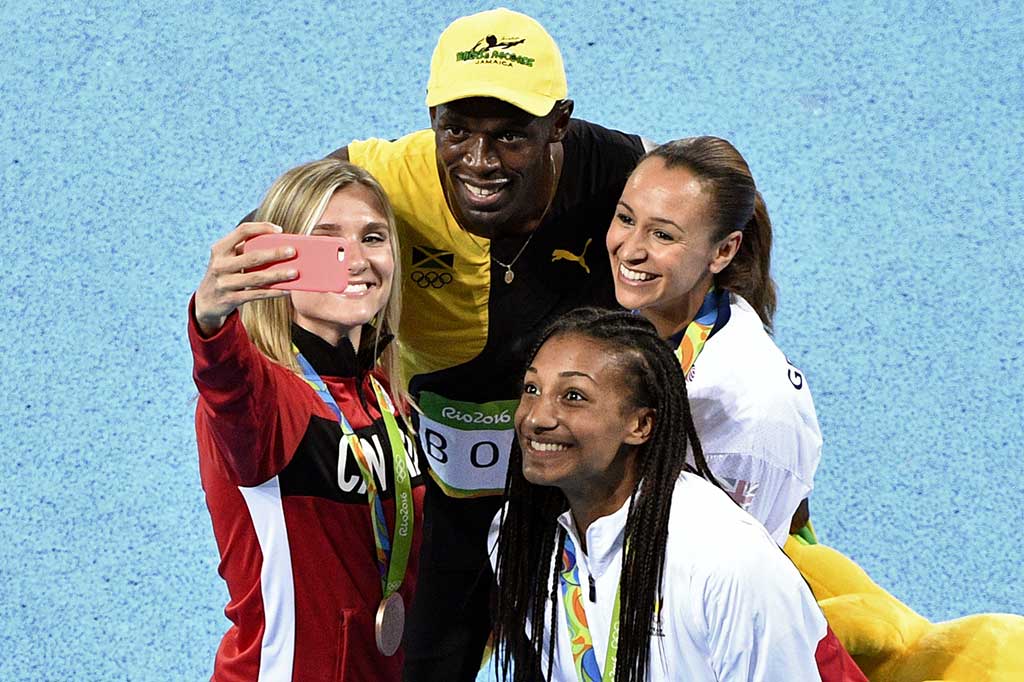 Bolt berfoto selfie bersama pelari perempuan usai menjadi juara 100 m olimpiade.