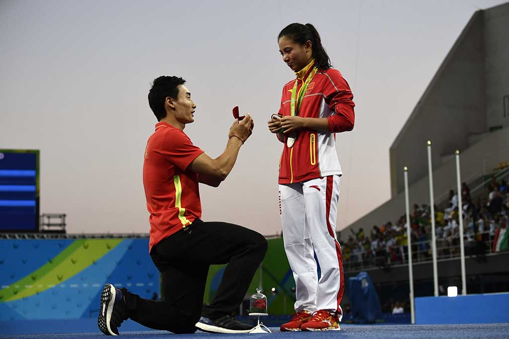 Di depan sorotan kamera stasiun televisi dunia, Qin Xai bertekuk lutut untuk melamar He Zi di atas podium Olimpiade Rio.