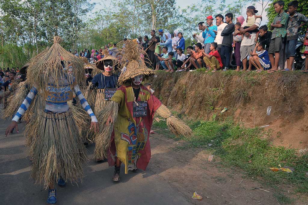 Warga menggunakan kostum memeden atau orang-orangan sawah saat mengikuti 'Festival Memeden Gadhu'.
