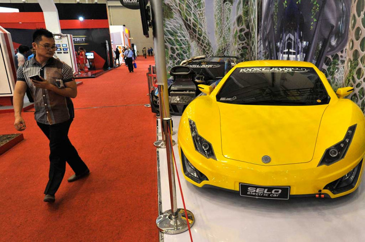 Pengunjung berjalan di samping Selo, mobil listrik produksi Indonesia.