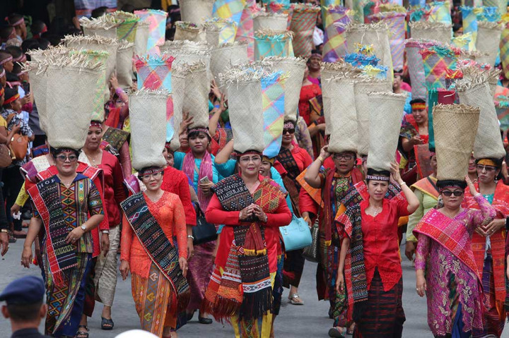 Puluhan wanita membawa wadah berisi beras (tandok) pada Karnaval Kemerdekaan Pesona Danau Toba (KKPDT).