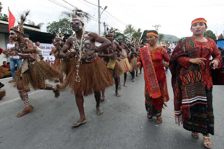 Penari asal Papua menari bersama warga suku Batak tampil pada Karnaval Kemerdekaan Pesona Danau Toba (KKPDT).