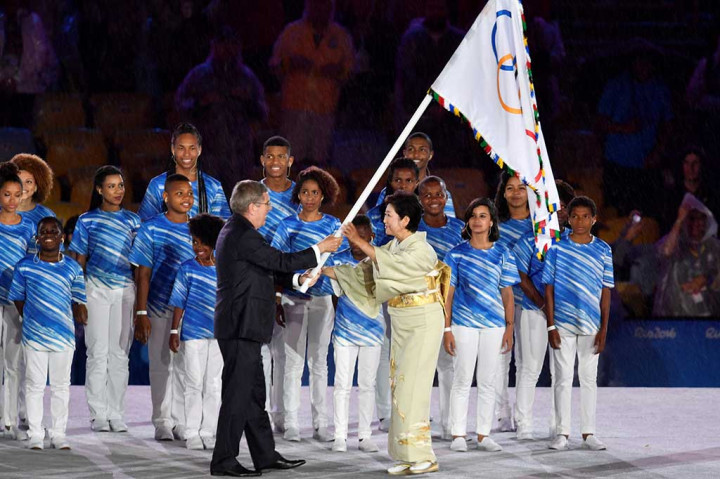 Ketua Komite Olimpiade Internasional (IOC) Thomas Bach menyerahkan bendera Olimpiade kepada Gubernur Tokyo Yuriko Koike, menandai transisi menuju Olimpiade Tokyo 2020.
