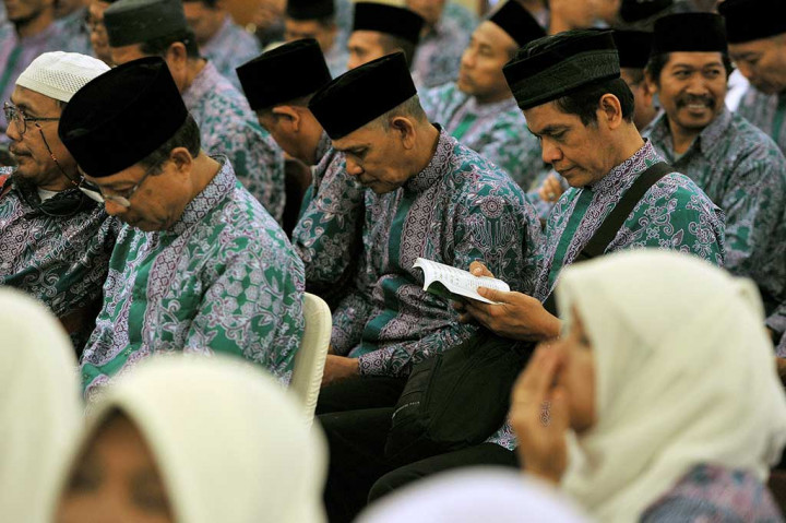 Seorang jemaah calon haji membaca buku panduan.