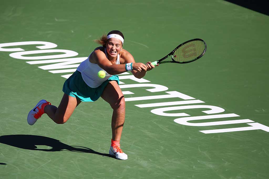 Ostapenko berusaha mengejar bola dari Wozniacki.