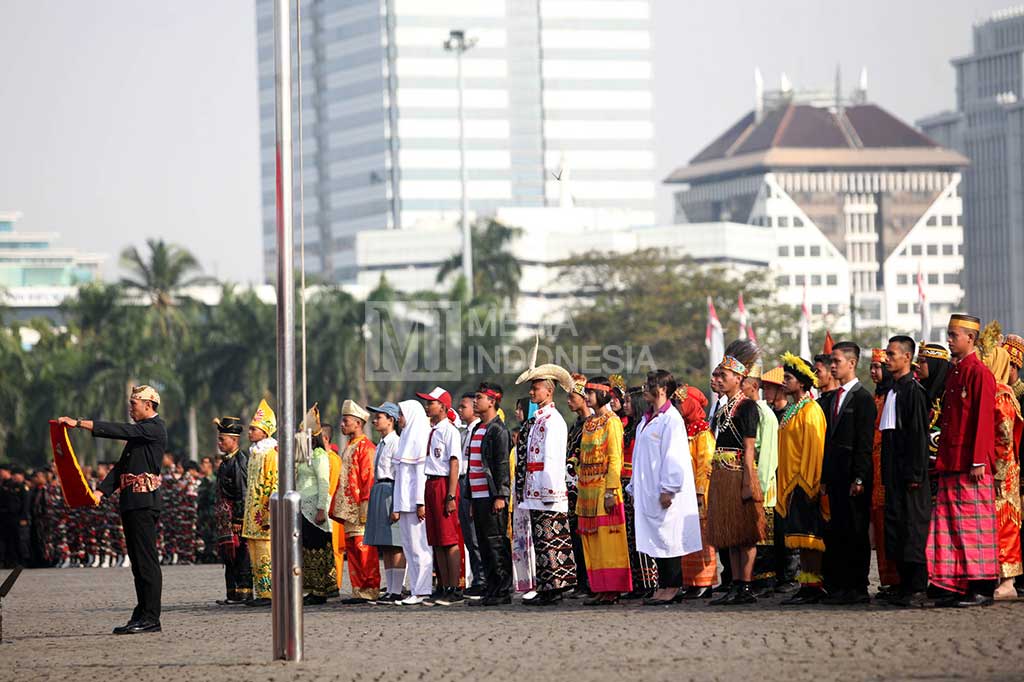 Peserta berpakaian adat dan pakaian sekolah membacakan Ikrar Bela Negara.