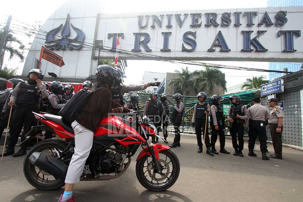 Seorang mahasiswa tidak dapat masuk ke dalam kampus yang dijaga polisi di halaman Universitas Trisakti, Jakarta.