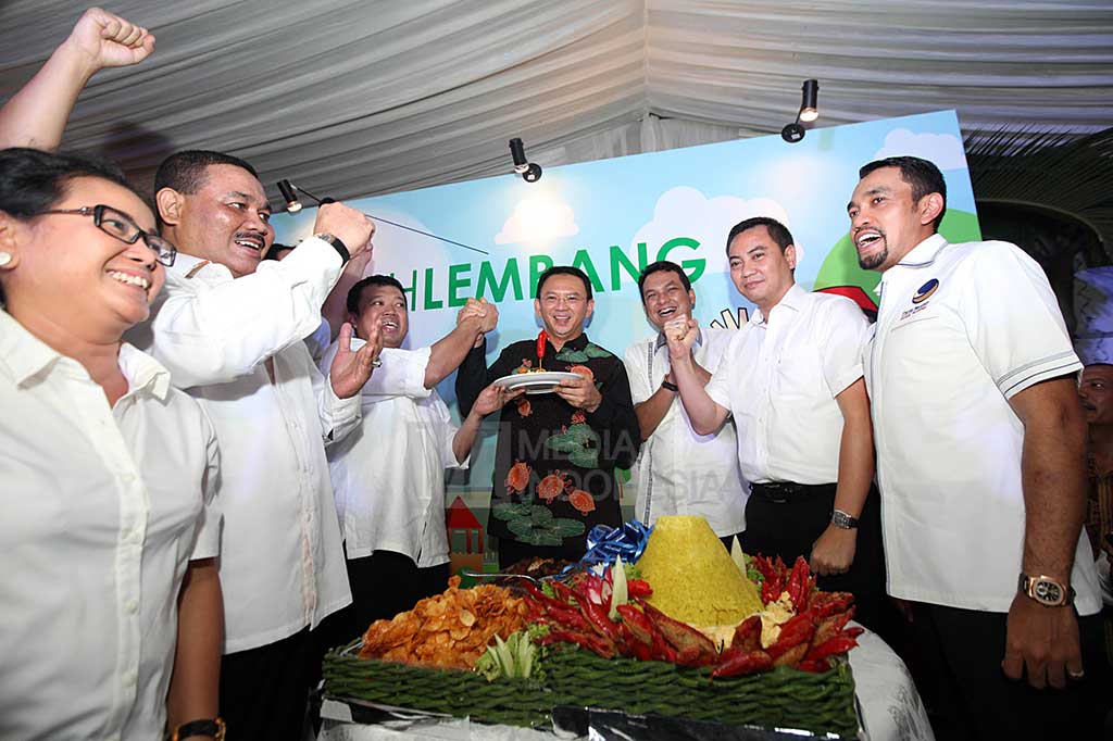 Ahok menerima potongan tumpeng dari Ketua Tim Pemenangan Ahok, Nusron Wahid, pada peresmian 'Rumah Lembang'.
