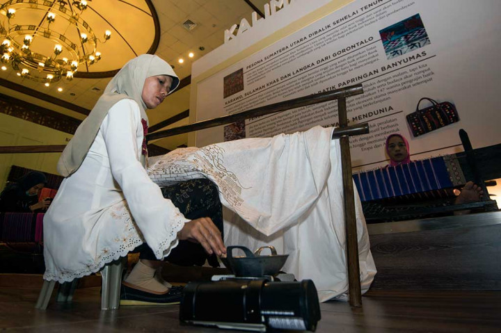 Perajin menyelesaikan proses pembuatan batik tulis dalam pameran kerajinan di Balai Sarbini.