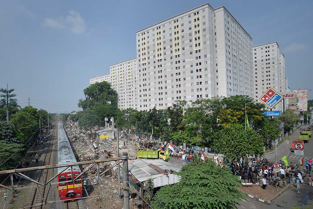 KRL melintas di samping permukiman warga yang ditertibkan Satpol PP di RT 09 RW 04, Kelurahan Rawajati, Pancoran, Jakarta Selatan, Kamis (1/9/2016).