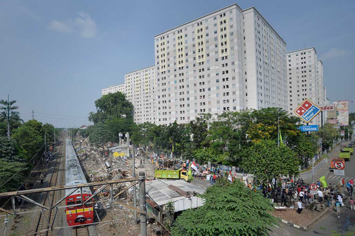 KRL melintas di samping permukiman warga yang ditertibkan Satpol PP di RT 09 RW 04, Kelurahan Rawajati, Pancoran, Jakarta Selatan, Kamis (1/9/2016).