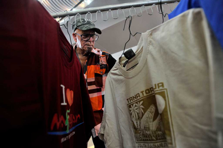 Seorang turis penumpang kapal pesiar Pacific Eden memilih baju khas Sulsel di Pelabuhan Sukarno-Hatta Makassar.