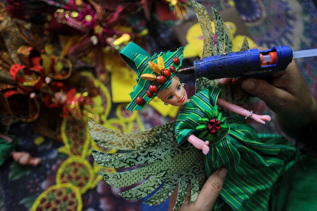 Para pengrajin di Manahan Solo, Jawa Tengah membuat miniatur boneka karnaval berbahan limbah kain perca.