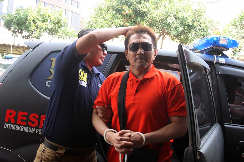 Ketua Umum (Parfi) Gatot Brajamusti alias AA Gatot dikawal petugas saat menjalani pemeriksaan di Subdit Resmob Dit Reskrimum Polda Metro Jaya, Jakarta, Senin (5/9/2016).