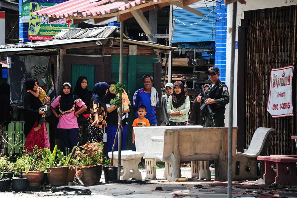 Warga melihat aparat keamanan yang tengah melakukan penyelidikan.