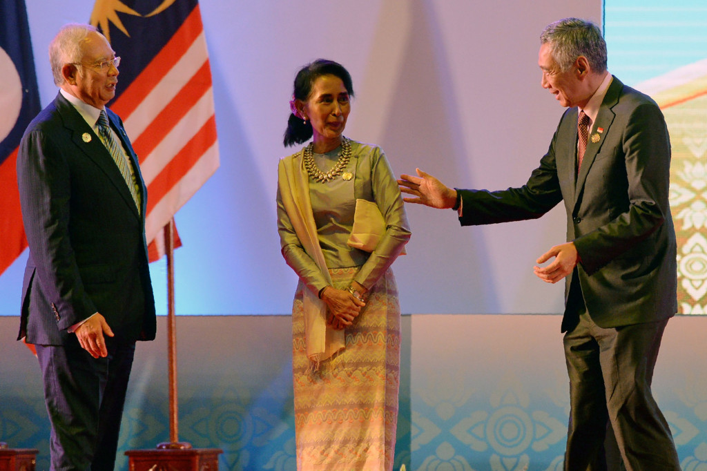 Menlu Laos Aung San Suu Kyi beramah tamah dengan PM Malaysia Najib Razak dan PM Singapura Lee Hsien Loong seusai upacara pembukaan ASEAN Summit. AFP PHOTO / ROSLAN RAHMAN