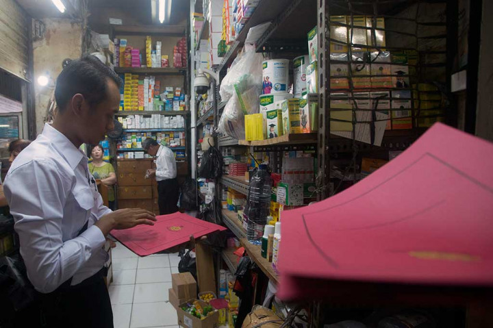 Petugas memeriksa obat yang dijual di apotek di Pasar Pramuka.
