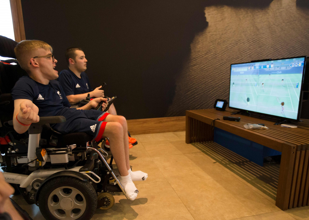 Patrick Wilson dan Jamie McCowan dari Inggris bermain video game di perkampungan atlet. Mereka adalah atlet boccia yang merupakan olahraga yang didesain khusus untuk dimainkan oleh para penyandang cacat. AFP PHOTO / OIS / IOC / Al Tielemans 