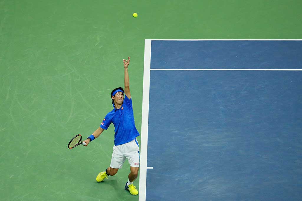 Kei Nishikori melancarkan servis ke arah petenis Britania Raya Andy Murray.