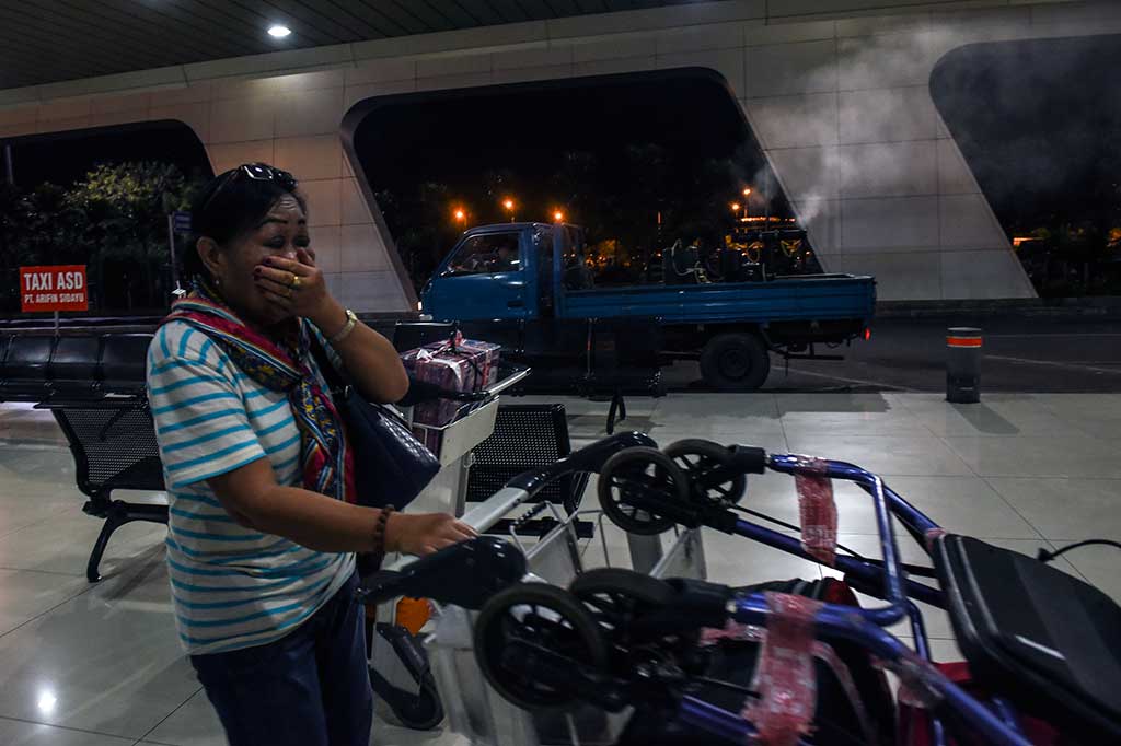 Penumpang menutup hidungnya ketika petugas melakukan pengasapan.