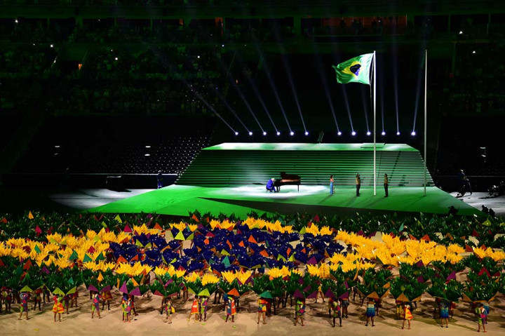 Penari dengan busana warna-warni beraksi di atas panggung.