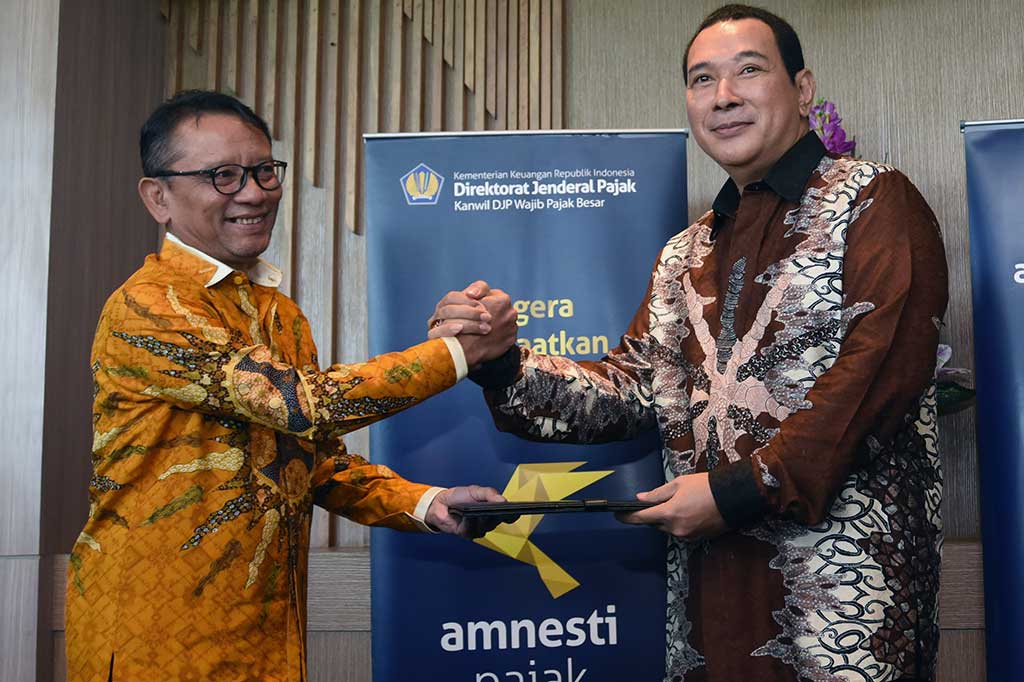 Dirjen Pajak Ken Dwijugiasteadi (kanan) menyerahkan tanda terima surat pelaporan harta kepada pengusaha nasional Hutomo Mandala Putra (Tommy Soeharto) di Kanwil Pajak Besar IV Sudirman, Jakarta, Kamis.