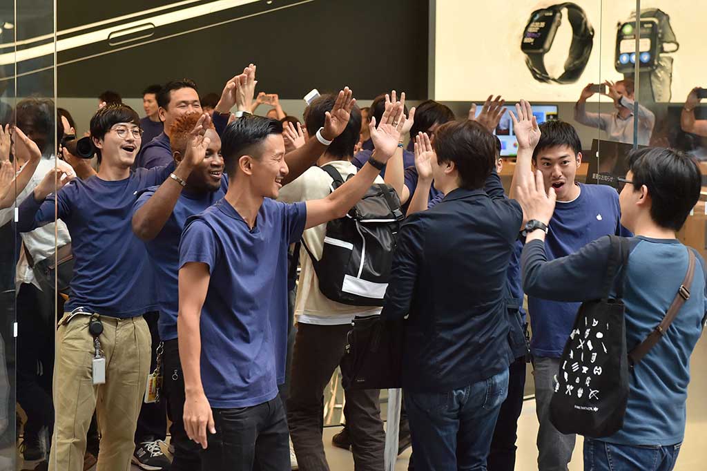 Karyawan Apple menyapa pelanggan pertama pembeli iPhone 7 di Tokyo, Jepang.