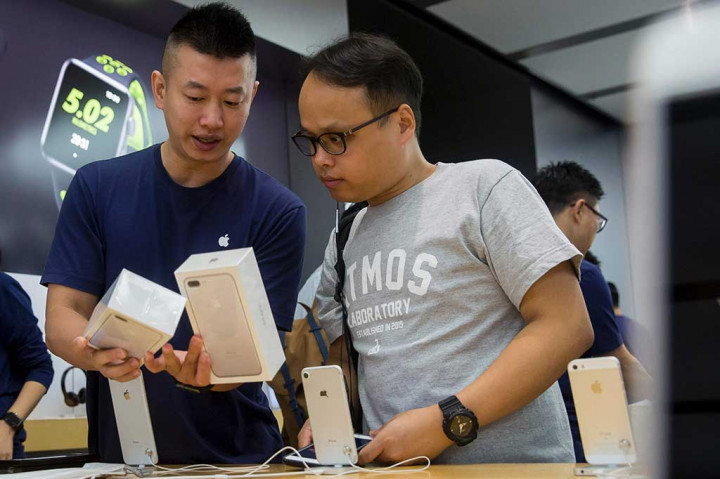 Karyawan memperlihatkan fitur-fitur smartphone iPhone 7 kepada pelanggan di Hong Kong.