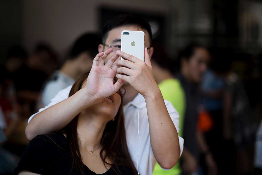 Pelanggan tengah menguji kecanggihan iPhone 7 di Beijing, Tiongkok.