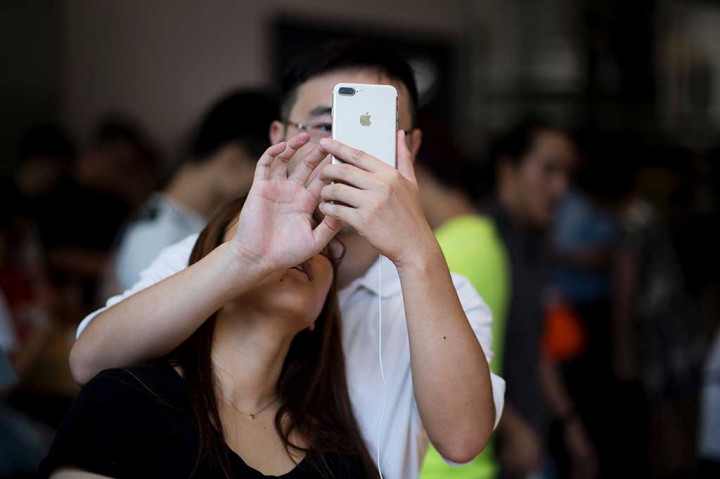 Pelanggan tengah menguji kecanggihan iPhone 7 di Beijing, Tiongkok.
