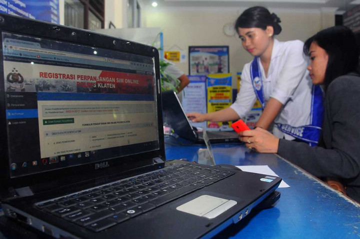 Petugas membantu warga mengisi formulir pembuatan Surat Izin Mengemudi (SIM) online di Polres Klaten, Jawa Tengah, Jumat (16/9/2016). 