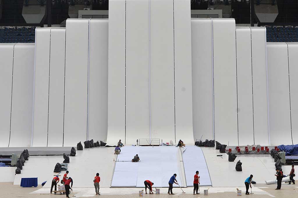 Pekerja mempersiapkan panggung yang akan digunakan untuk pembukaan PON XIX.