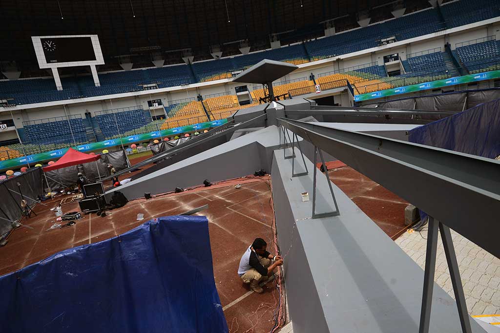 Pekerja mengecek sistem kelistrikan untuk acara pembukaan PON XIX.