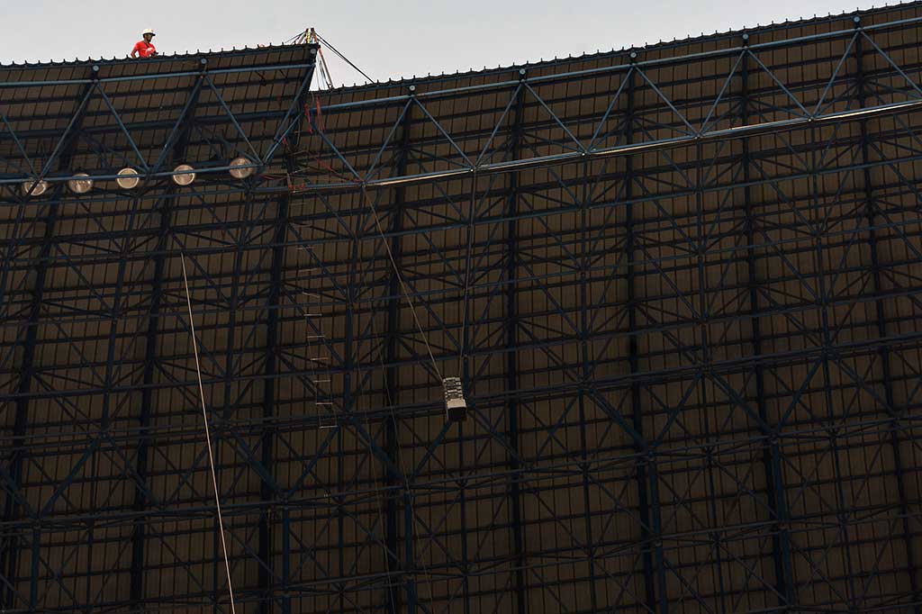 Pekerja mengecek lampu dan pengeras suara yang akan digunakan untuk pembukaan PON XIX.