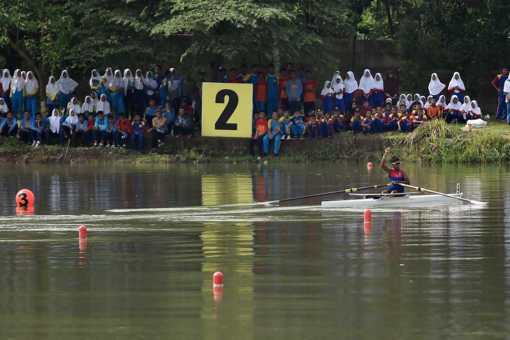 Atlet Dayung Maluku Chelsea Corputty mengangkat tangan setelah menyentuh garis finis pertama pada nomor Rowing Single Sculls Kelas Ringan Putri 2000.